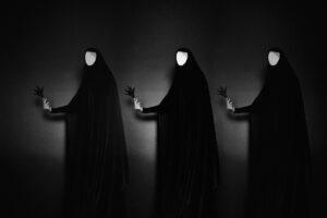 Three faceless figures in dark cloaks, minimalist art.