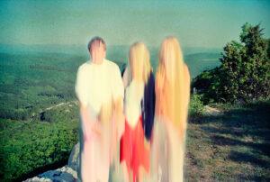 Blurry people standing on a scenic hillside.