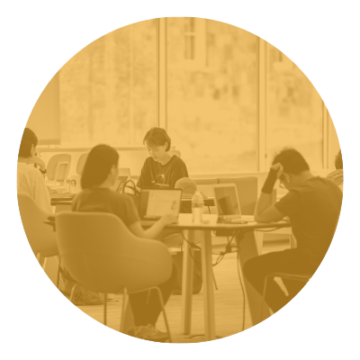 People studying in a library, working on laptops.