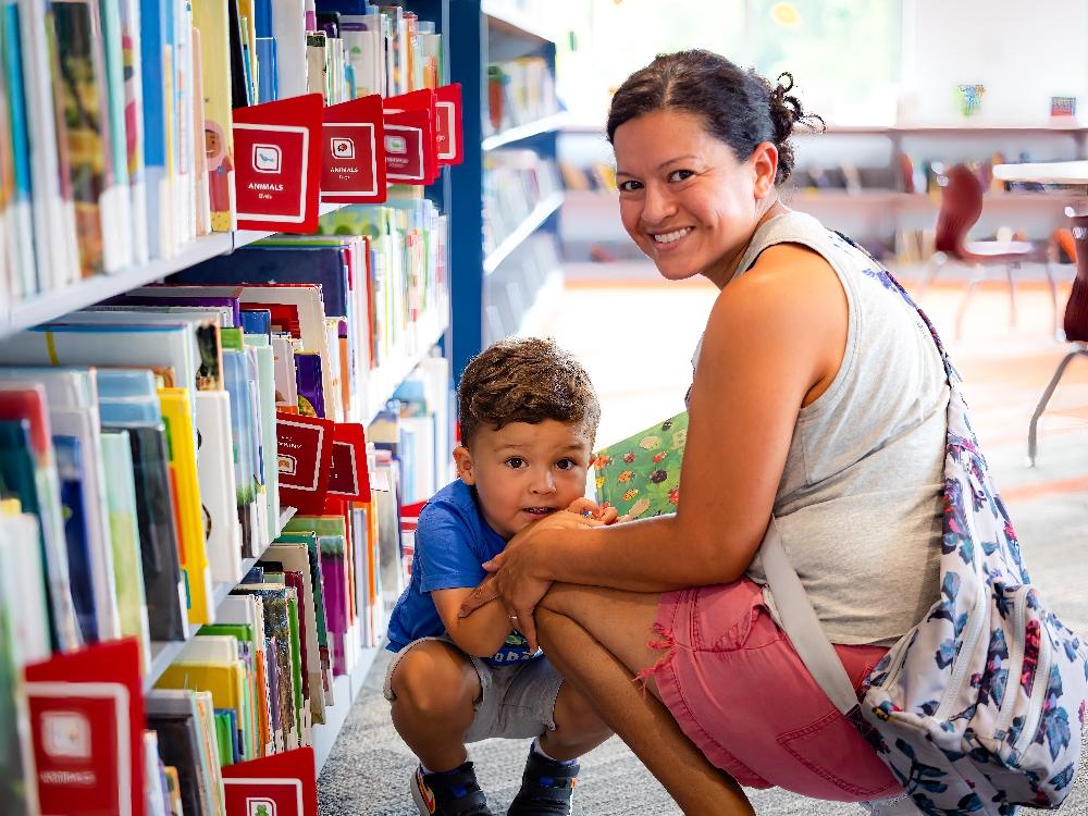 Mother and child reading in library.