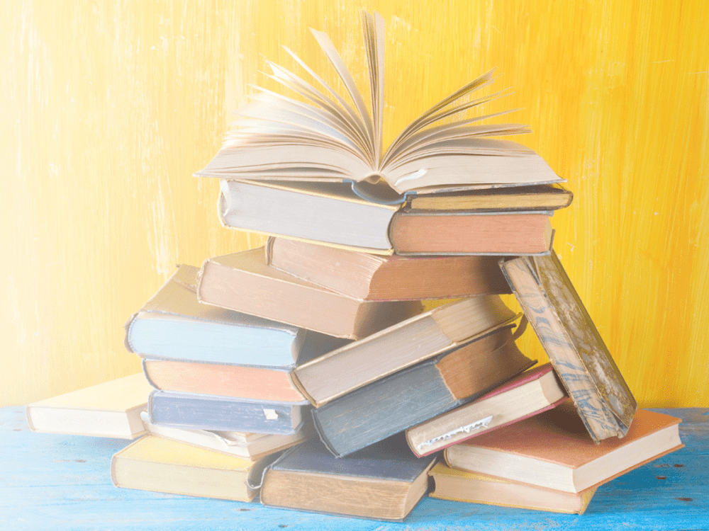 Stack of colorful books on blue table.