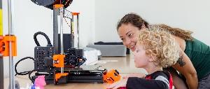 Child and woman learning 3D printing together.