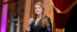 Woman in black gown speaking on stage