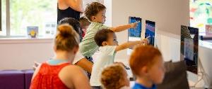 Children engaged with tablets in a learning center.