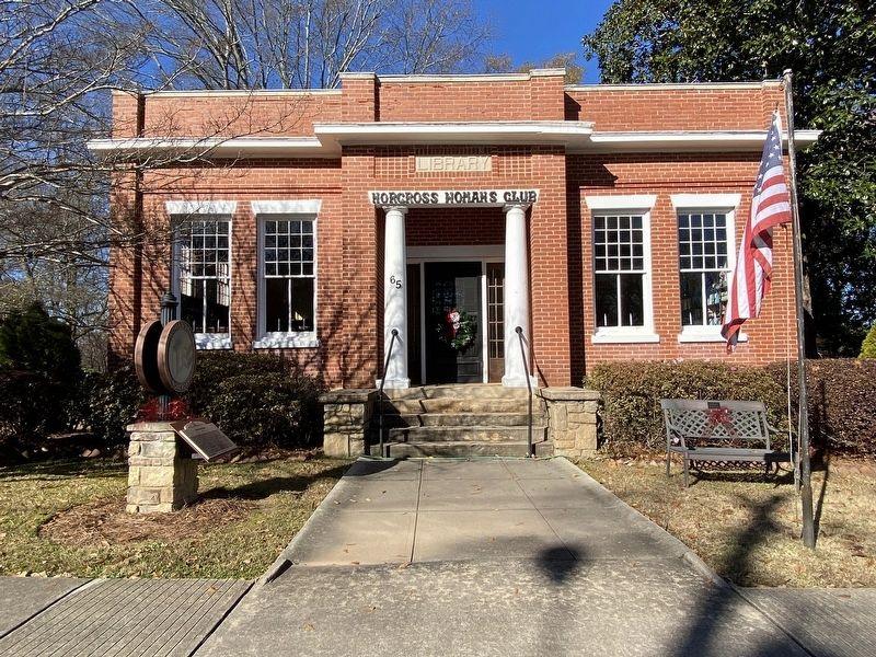 Historic Norcross Woman's Clubhouse with American flag outside.