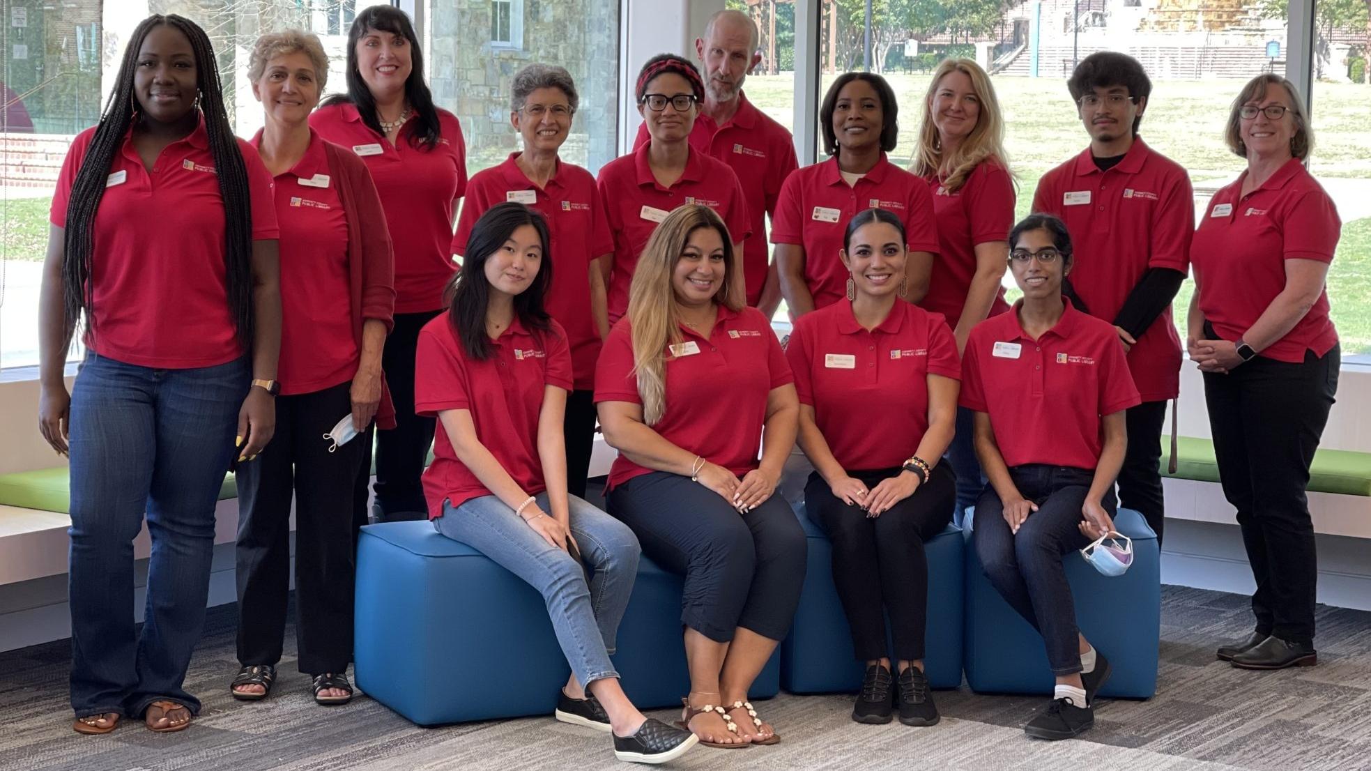 Group photo of people in red shirts indoors.