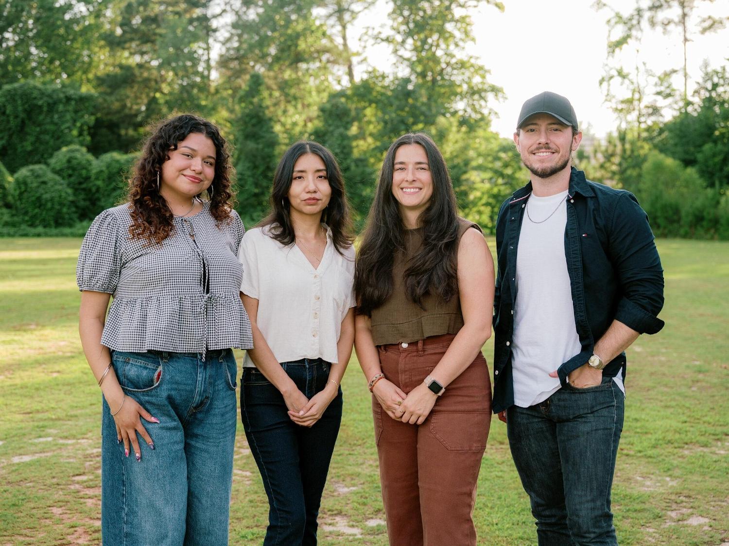 Diverse group of people smiling outdoors.
