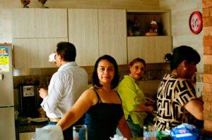 Four people socializing in a kitchen setting.