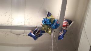 Patriotic balloons stuck on a ceiling.