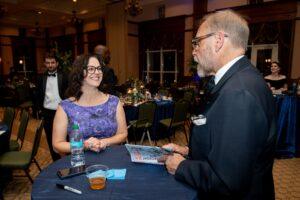 Woman chats with man at formal banquet