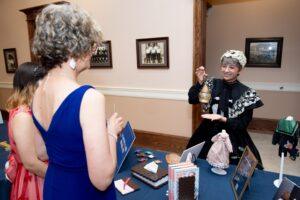 Costumed exhibitor displays antique lantern at museum event