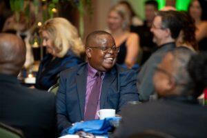 Smiling man in suit at a formal dinner