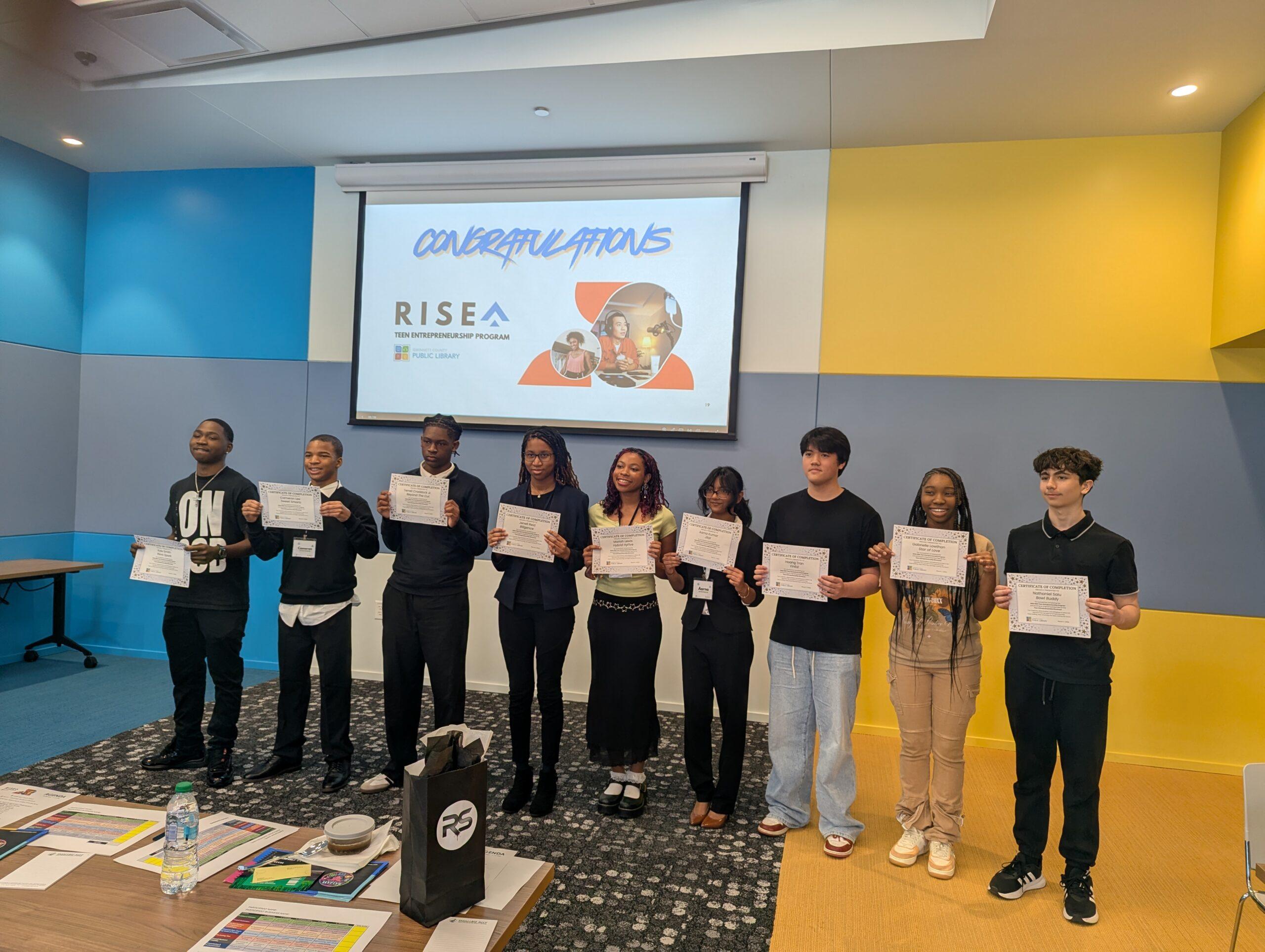 Teen entrepreneurs hold certificates at RISEA program celebration.